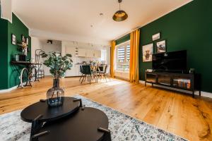 sala de estar con paredes verdes y mesa en Klassen Stay - Exklusives Apartment - Zentral und 4km zur Messe -Kingsizebett en Essen