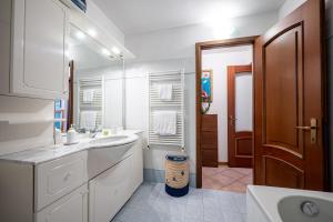 bagno bianco con lavandino e specchio di Apartment with bicycle storage in Dongo - Larihome A24 a Dongo