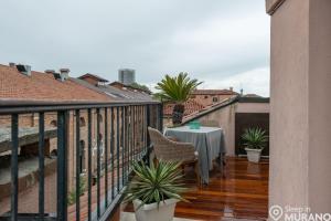 uma varanda com uma mesa e cadeiras num edifício em MURANO Suites BOUTIQUE Apartments em Murano