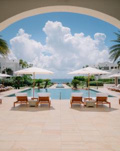 a pool at a resort with chairs and umbrellas at Aurora Anguilla Resort & Golf Club in Ebenezer