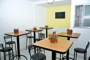 una stanza con quattro tavoli e sedie con fiori di Hotel Ellegance a Salvador