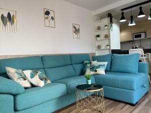 a blue couch in a living room with a table at Poema de Liria in Caleta De Fuste
