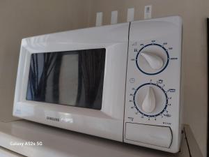 - un four micro-ondes blanc installé au-dessus d'un comptoir dans l'établissement Appartement entier à une chambre à coucher, à Agadir