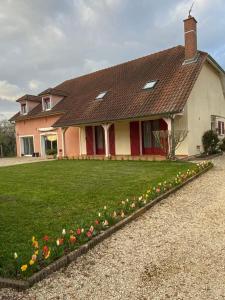 a house with a bunch of flowers in front of it at AU FIL DES LACS in Précy-Saint-Martin