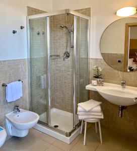 ein Bad mit einer Dusche und einem Waschbecken in der Unterkunft Hotel Granada in Milano Marittima