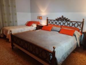 two beds with orange pillows in a bedroom at Bed and Breakfast Big Brother in Treviso