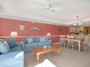 a living room with a blue couch and a table at Beachside Colony in Tybee Island