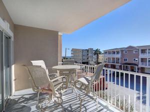 a patio with a table and chairs on a balcony at Beachside Colony in Tybee Island