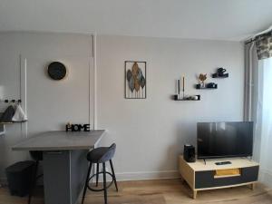 a living room with a tv and a table and a desk at Ravissant appart' central in Châteauroux