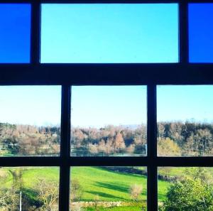 uma vista a partir de uma janela de um campo e árvores em Casa do Fundo - Sustainable & Ecotourism em Seia