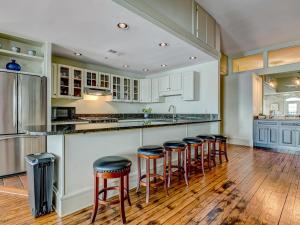 een keuken met witte kasten en barkrukken bij Riverview Penthouse in Savannah