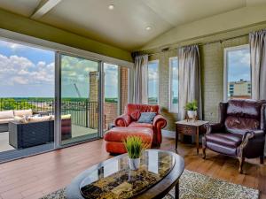 een woonkamer met meubilair en een groot raam bij Riverview Penthouse in Savannah