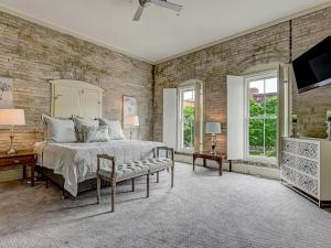 een slaapkamer met een bed en een bakstenen muur bij Riverview Penthouse in Savannah
