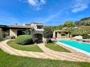 a villa with a swimming pool and a house at Villa Hibiscus Stintino in Stintino