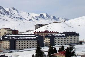 eine Stadt mit schneebedeckten Gebäuden und einem Berg in der Unterkunft Apartamentos Reservas León in San Isidro