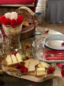 un tavolo con formaggio, fragole e un vaso di rose di Al Silter a Capriate San Gervasio