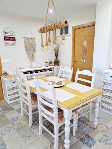 een eetkamer met een witte tafel en stoelen bij Casa de los Suenos Granada 