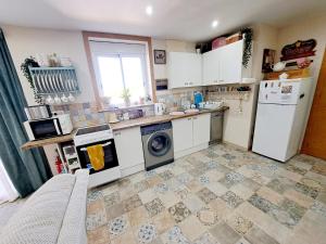 uma cozinha com electrodomésticos brancos e piso em azulejo em Casa de los Suenos Granada 