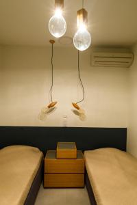 a room with two beds and two lights on the wall at Athens riviera beach villa in Anavissos +8 photos