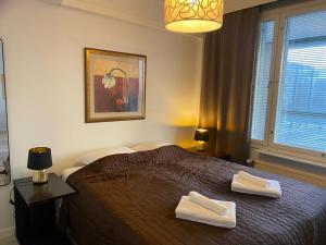 um quarto com uma cama com duas toalhas em Gella Serviced Apartments Office em Helsinque