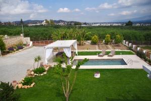 un patio trasero con piscina y dosel blanco en Private Villa Freedom, en Moírai