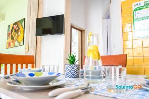einen Esstisch mit einer Flasche Limonade drauf in der Unterkunft Appartamenti Jolly by SalentoGo in Torre Lapillo