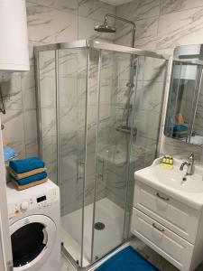 eine Duschkabine im Bad mit einer Waschmaschine in der Unterkunft Apartma Sunrise Piran in Piran