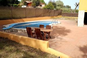 - une table et des chaises à côté de la piscine dans l'établissement Casa independiente , piscina, naturaleza y relax, 