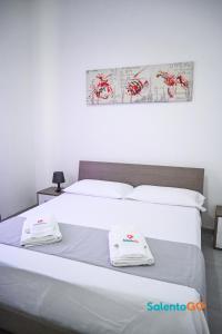 ein Schlafzimmer mit einem Bett mit zwei weißen Handtüchern darauf in der Unterkunft Appartamenti Jolly by SalentoGo in Torre Lapillo