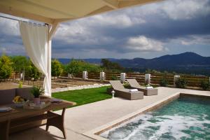 un patio con piscina, sillas y mesa en Private Villa Freedom, en Moírai