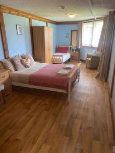 ein Schlafzimmer mit einem großen Bett und Holzboden in der Unterkunft Haven of Trees - Hafan Y Coed in Abercraf