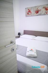 ein Hotelzimmer mit 2 Betten mit weißer Bettwäsche in der Unterkunft Appartamenti Jolly by SalentoGo in Torre Lapillo