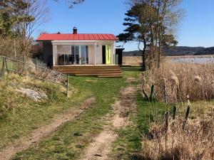 una pequeña casa con techo rojo en un campo en Lycke - By the sea, en Lycke