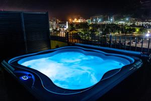 un jacuzzi en el balcón por la noche en Apartamentos Turísticos Puerta Real, en Cartagena