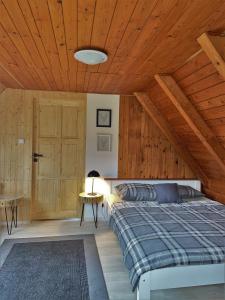 sypialnia z łóżkiem i drewnianym sufitem w obiekcie Chata Pinie w mieście Ivančice
