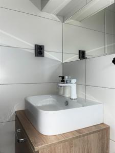 W łazience znajduje się biała umywalka i lustro. w obiekcie Chata Pinie w mieście Ivančice