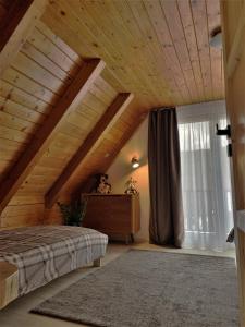 a bedroom with a bed and a wooden ceiling at Chata Pinie in Ivančice
