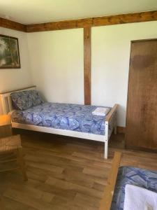 Schlafzimmer mit einem Bett und Holzboden in der Unterkunft Haven of Trees - Hafan Y Coed in Abercraf