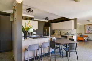 a kitchen with a table and chairs in a room at Private Heated Pool Walk to Isla Verde Beach in San Juan