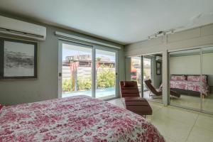 a bedroom with a large bed and a balcony at Private Heated Pool Walk to Isla Verde Beach in San Juan +37 photos