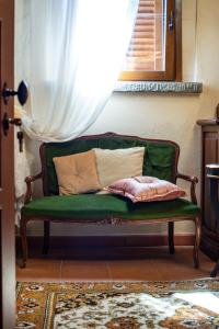 a green couch with pillows on it in a room at Castellino di Malborghetto in Montelupo Fiorentino