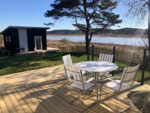 a table and chairs on a deck next to a lake at Lycke - By the sea in Lycke