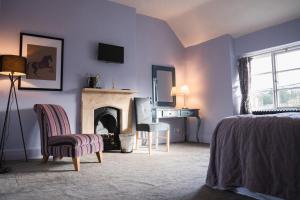 um quarto com uma lareira, uma cama e uma cadeira em The George Inn Wedmore em Wedmore