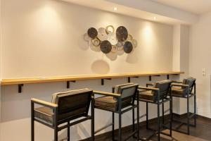 a room with chairs and a counter with plates on the wall at Moselhotel Weinhaus Simon in Wintrich