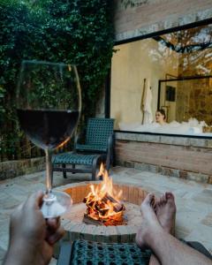 a person holding a glass of wine next to a fire pit at LaPianta in Monte Verde