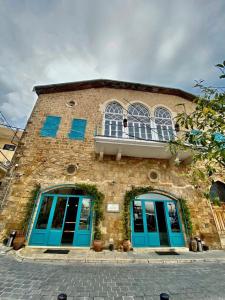 a brick building with blue doors and a balcony at Dar Alice in Soûr