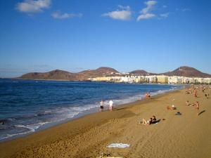 un grupo de personas en una playa cerca del agua en Casa La Isleta, playa Las Canteras, puerto y tranquilidad, en Las Palmas de Gran Canaria