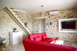 sala de estar con sofá rojo y pared de ladrillo en Private Villa Freedom, en Moírai