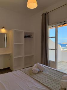 a bedroom with a bed with a view of the ocean at Juli’s Suites in Mérikhas