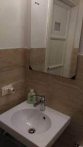 y baño con lavabo blanco y espejo. en A Due Passi Dal Treno, en Pisa